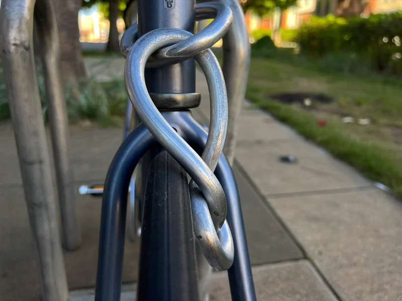 Spiralschloss durch Rahmen und Laufrad am Fahrradständer, Illustration